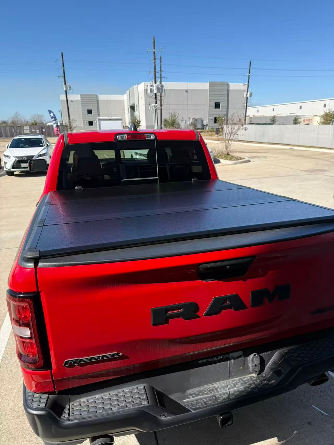 Closed hard tri-fold tonneau cover on a red RAM pickup truck