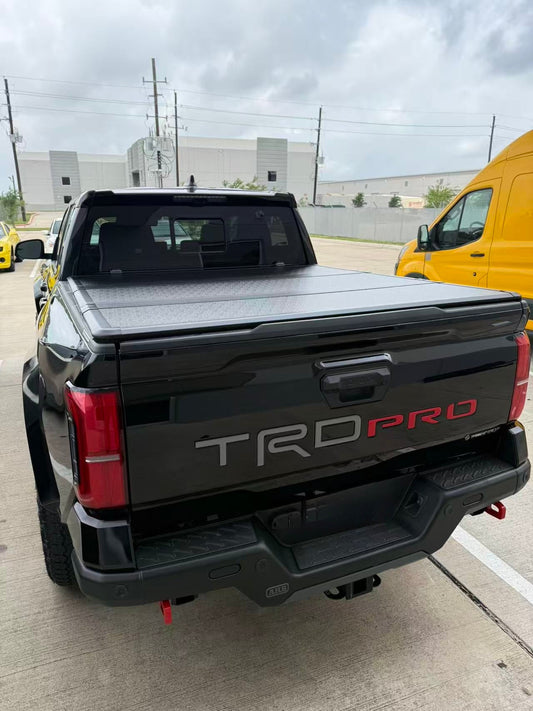 Closed hard tri-fold tonneau cover on a dark-colored Ford pickup truck